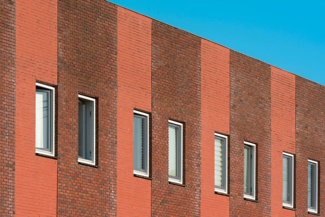 Klinkerfassade eines Wohngebäudes mit einer Reihe schmaler Fenster